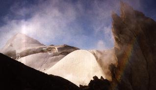 Steam rises from the summit crater with Sherman Peak in the background.